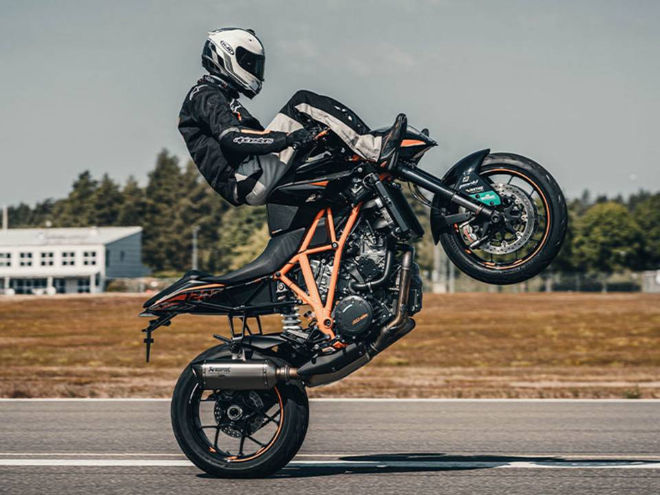 O dubl Magnus Carlsson empina sua KTM Duke 200 sentado sobre o guido